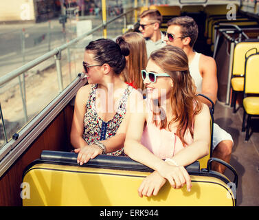 group of smiling friends traveling by tour bus Stock Photo