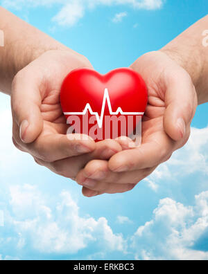 close up of hands holding heart with cardiogram Stock Photo