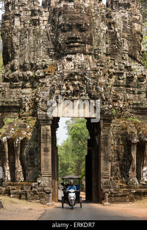 Victory Gate in the east of Angkor Thom, tuk-tuk in front of a Avalokiteshvara face tower, western view, Angkor Thom, Siem Reap Stock Photo