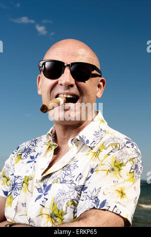 man in Hawaiian shirt,sunglasses and cigar on holiday Stock Photo