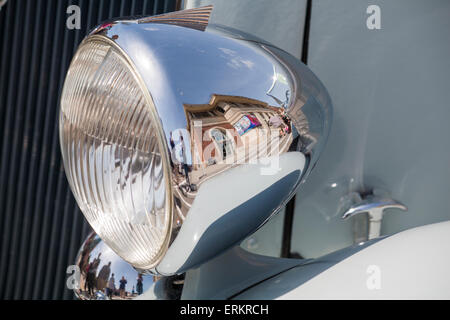 The Pavilion Theatre reflected in shining metal chrome headlight of classic car at Bournemouth, Dorset, UK in May Stock Photo