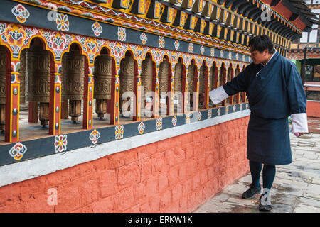 A man rotates the roller-books of the Monastery of Rinpung Dzong which are used to pray, Paro, Bhutan, Asia Stock Photo