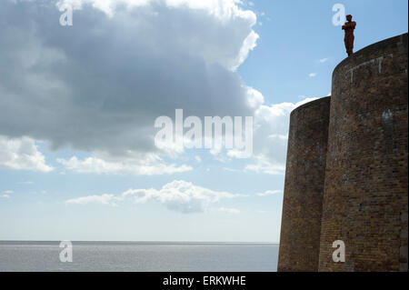 Antony Gormley's sculpture of a man looking out to sea, standing on the Napoleonic Martello tower in Aldeburgh, Suffolk, England Stock Photo