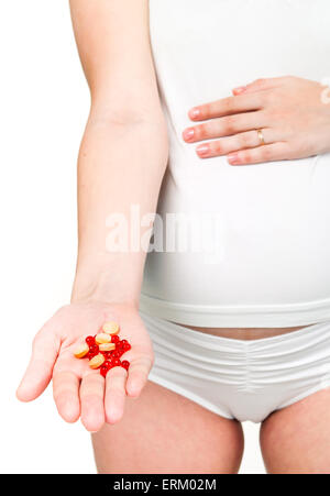 Pregnant woman holding pills. Stock Photo