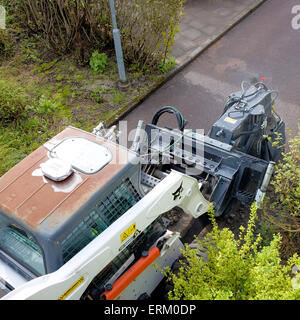 Trench digger trenching in preparation for high speed fiber internet installation in residential area  Model Release: No.  Property Release: No. Stock Photo