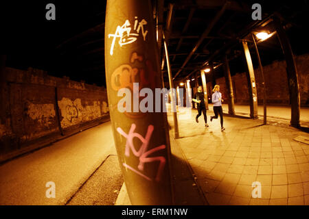 A couple runs through a dark tunnel in downtown Hamburg, Germany. Stock Photo