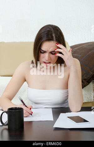 Stressed caucasian woman student learning from notes. Girl worried about exams. People, knowledge, education, literature and sch Stock Photo