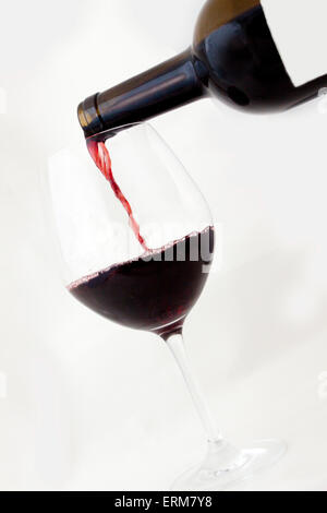 Blank Red Wine Bottle pouring into glass Stock Photo