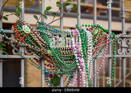 New Orleans, Louisiana - Mardi Gras beads hanging on a fence in the Garden District. Stock Photo