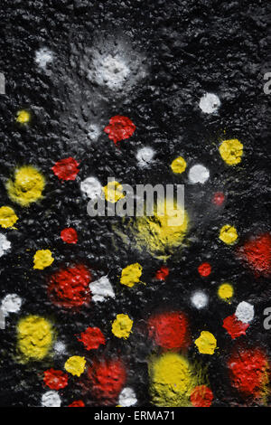 Colorful spray painted dots on textured wall abstract background. Stock Photo