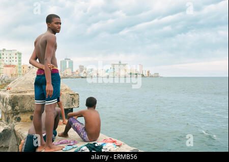 HAVANA, CUBA -  MAY, 2011: Young Cubans gather on the wall of the Malecon to take turns jumping in the sea. Stock Photo