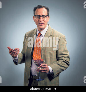 Drunk man in suit speaking with his tie in his martini Stock Photo