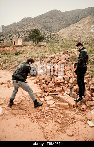 Guy working hard with a bystander doing nothing, a concept Stock Photo