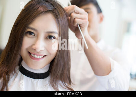 Young woman having haircut in barber shop Stock Photo
