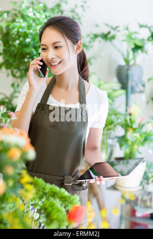 Female florist talking on the phone in shop Stock Photo