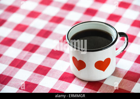 Coffee served in an old enamel mug with hearts Stock Photo