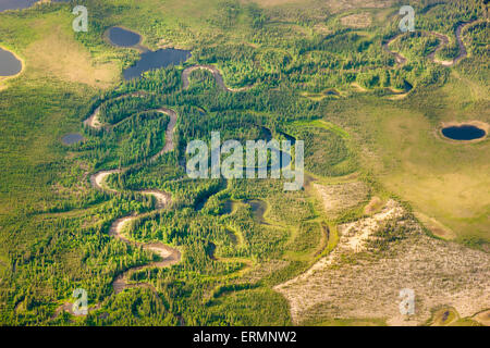 Aerial view of green tundra and a narrow, winding stream, sand dunes and small lakes, Arctic Alaska, summer Stock Photo