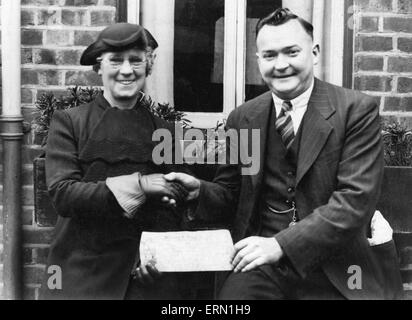 Birmingham City football star Joe Bradford presents a cheque for £3289 to Mrs F Holland, her dividend for a stake of one penny in the Everyman's Football Pool. November 1953. Stock Photo