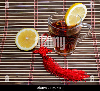glass of tea on a rug with a lemon Stock Photo