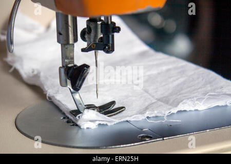 a closeup view of a sewing machine with a piece of cloth Stock Photo