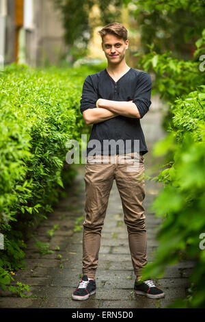 Full length portrait of happy handsome young man summer outdoors. Stock Photo