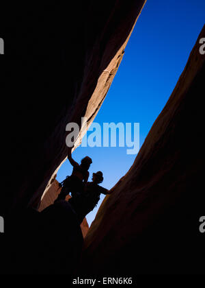 Adventurers exploring a desert slot canyon; Hanksville, Utah, United States of America Stock Photo