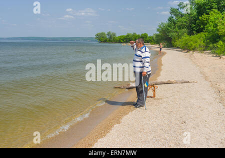 Senior man standing on the edge of the Dnepr river looking into the distance Stock Photo