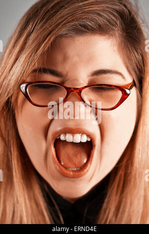 Cute nerdy girl with reading glasses yelling Stock Photo