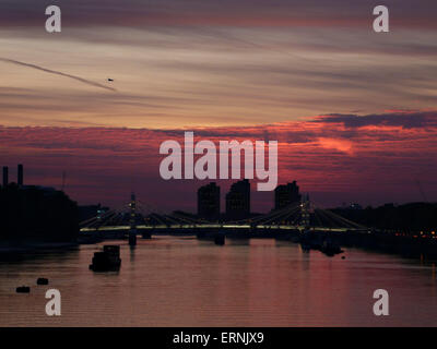 A dramatic sunset over the River Thames in Chelsea from Battersea Bridge with Albert Bridge in the background Stock Photo