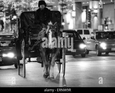 Chicago, IL, 14-Dec-1996: A horse carriage in dense traffic during the evening rush hour on Michigan Ave Stock Photo