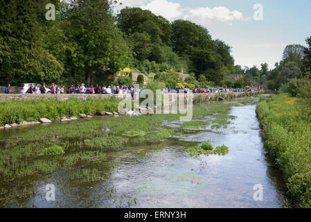 French school children walking along the River Coln in Bibury, Cotswolds, Gloucestershire, England