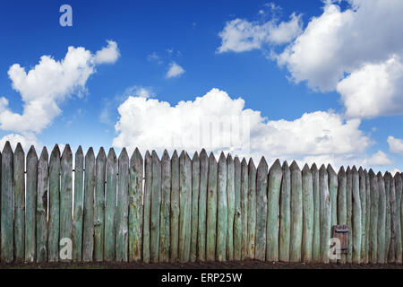 Old wooden fence against blue sky with clouds. Background for design Stock Photo