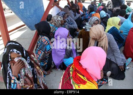 Tripoli, Libya. 06th June, 2015. A batch of illegal immigrants sit on the ground after being detained by Libyan coast guard near Garabulli, Libya on June 6, 2015. The Libyan coast guard intercepted dozens of sub-Saharan nationals trying to stow away to Europe from Libyan coast. Credit:  Xinhua/Alamy Live News Stock Photo