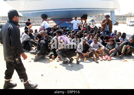 Tripoli, Libya. 06th June, 2015. A batch of illegal immigrants sit on the ground after being detained by Libyan coast guard near Garabulli, Libya on June 6, 2015. The Libyan coast guard intercepted dozens of sub-Saharan nationals trying to stow away to Europe from Libyan coast. Credit:  Xinhua/Alamy Live News Stock Photo