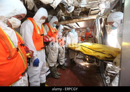 Paramilitary policemen stand in silent tribute to mourn  a body of a victim on the sank ship 'Eastern Star' on the bank of the Yangtze River in Jianli county, Hubei province, central China, 6th June 2015. There were 456 on board the Eastern Star when it sank in bad weather on 01 June. 14 people have been rescued alive after the ship sank. Stock Photo