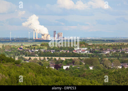 View from a slag heap over rural landscape to a distant steaming coal-fired power station. Stock Photo