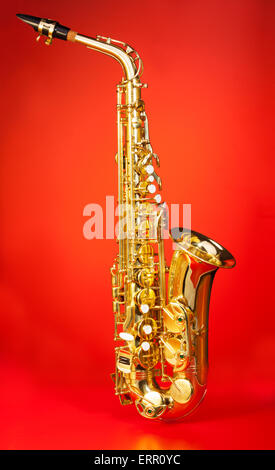 Alto saxophone in full length on red background Stock Photo