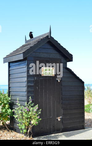 small wood fish smoke hut with crow on the roof Stock Photo