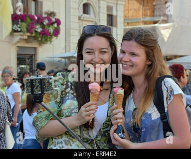 Two pretty women with ice cream cones taking a selfie near the fountains in Piazza Navona in Rome, Italy Stock Photo