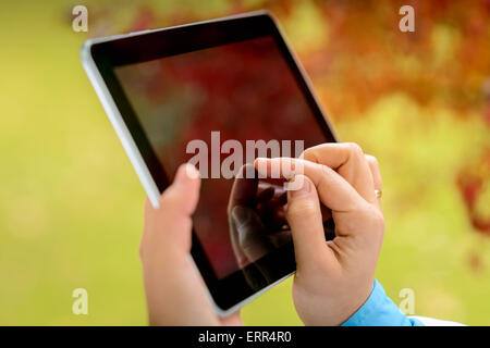 Women sitting with a tablet during the rainy autumn day Stock Photo