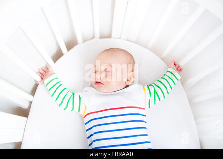 Cute newborn little boy sleeping in a white round crib Stock Photo