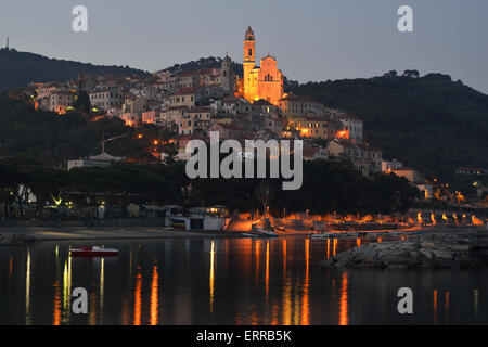 Seaside hilltop village at twilight with lights reflected on the sea. Cervo, Province of Imperia, Liguria, Italy. Stock Photo