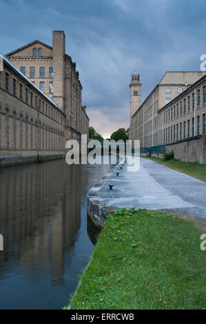 Salts Mill (grand, historic, Victorian factory or textile mill building by canal towpath) - banks of Leeds Liverpool Canal, Saltaire, England, UK. Stock Photo