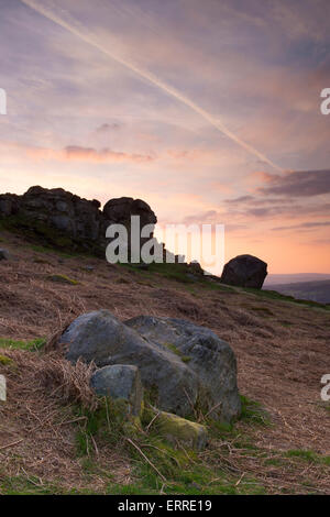 Beautiful rural scenic landscape of dramatic colourful sky at sunset over high rocky outcrop - Cow and Calf Rocks, Ilkley, West Yorkshire, England, UK