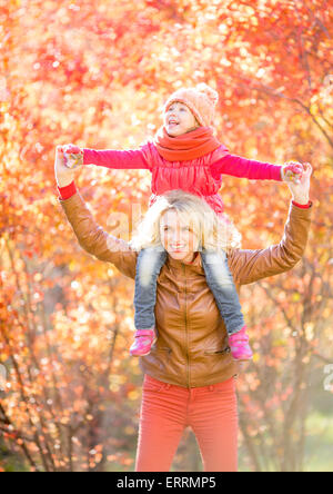 Happy parent and kid walking in fall outdoor Stock Photo