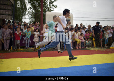 Chongqing, Chongqing, CHN. 6th June, 2015. Chongqing, CHINA - June 6 2015: (EDITORIAL USE ONLY. CHINA OUT) Men wearing high-heeled shoes run fast. The high-heeled shoes color run is held in Fuling District in Chongqing. All the participants are required to wear shoes with heels no less than 8cm and run 100 meters. © SIPA Asia/ZUMA Wire/Alamy Live News Stock Photo