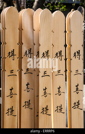 Wooden grave marker sticks, sotoba, AKA stupas, with Japanese kanji inscriptions written on in black ink, in cemetery in Tokyo, Japan. Stock Photo