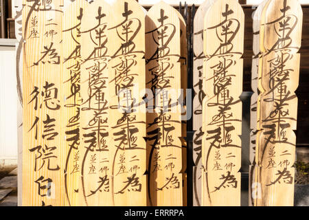 Wooden grave marker sticks, sotoba, AKA stupas, with Japanese kanji inscriptions written on in black ink, in cemetery in Tokyo, Japan. Stock Photo