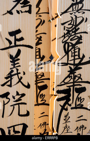 Wooden grave marker sticks, sotoba, AKA stupas, with Japanese kanji inscriptions written on in black ink, in cemetery in Tokyo, Japan. Stock Photo