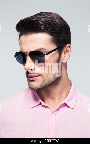 Handsome stylish man in sunglasses and shirt over gray background Stock Photo